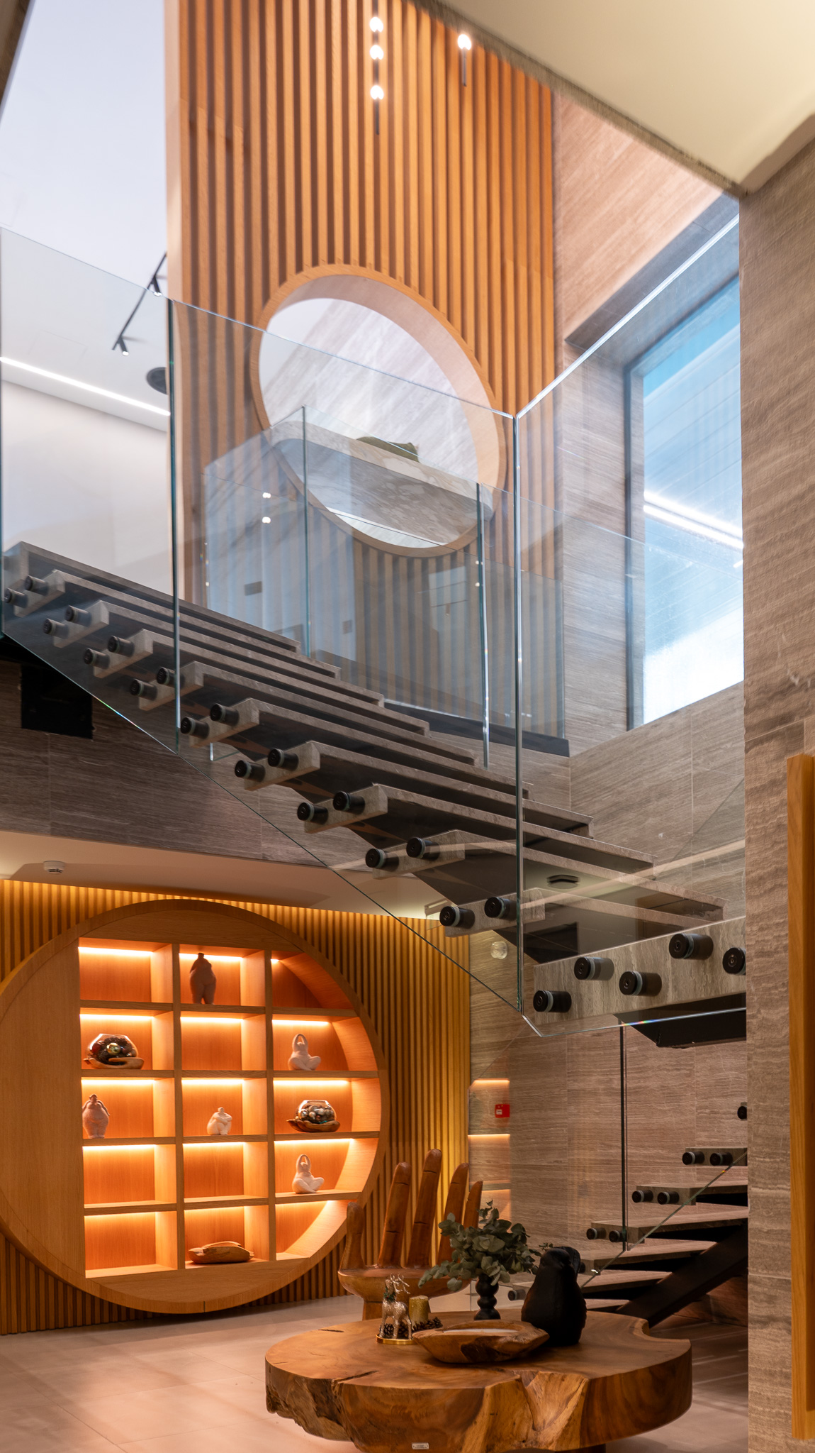 Dusit Suites Athens, double-height lobby atrium with floating glass-rail staircase