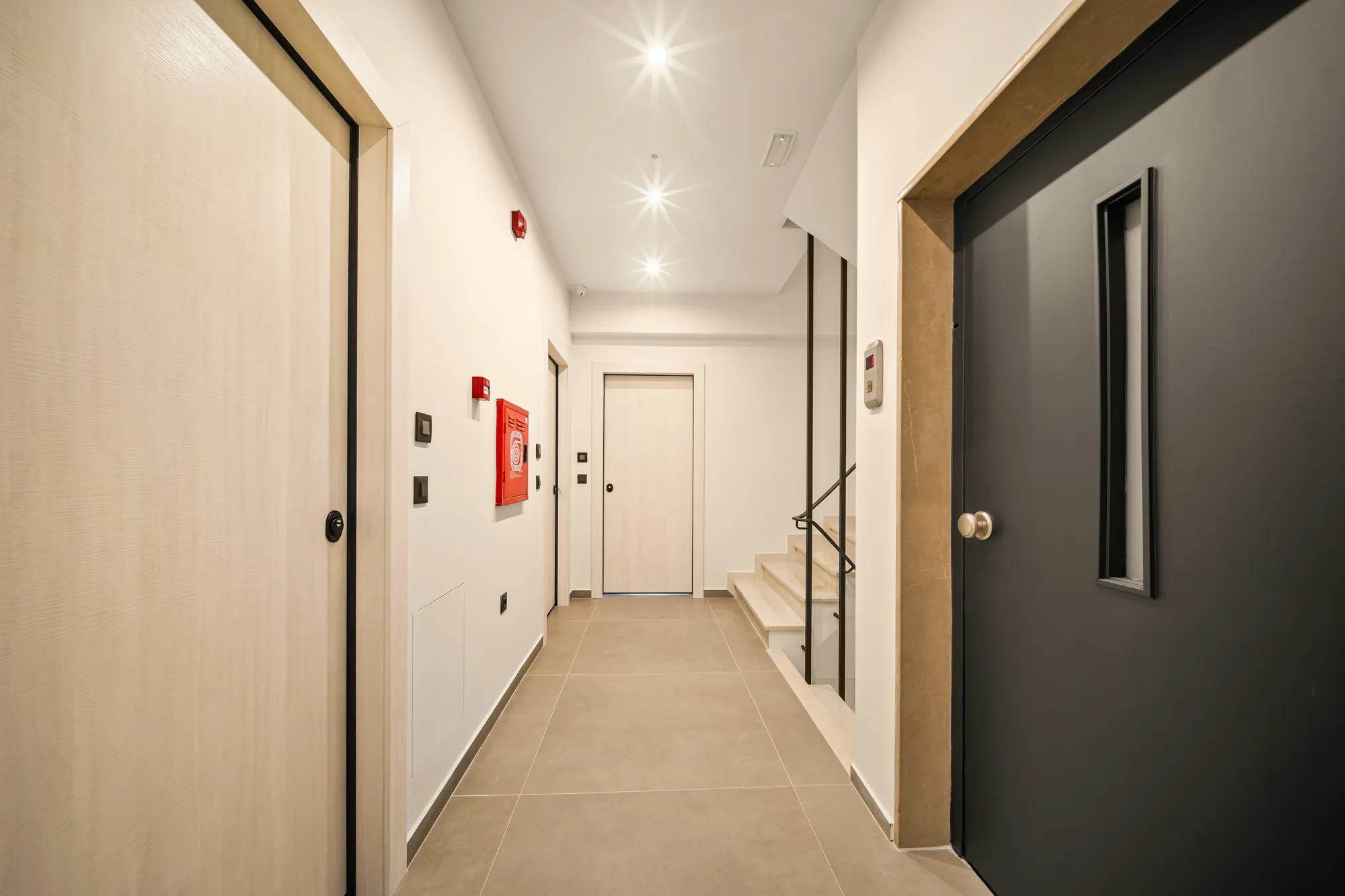 ORMOS Piraeus, the corridor to the rooms, oak doors and a black lift door