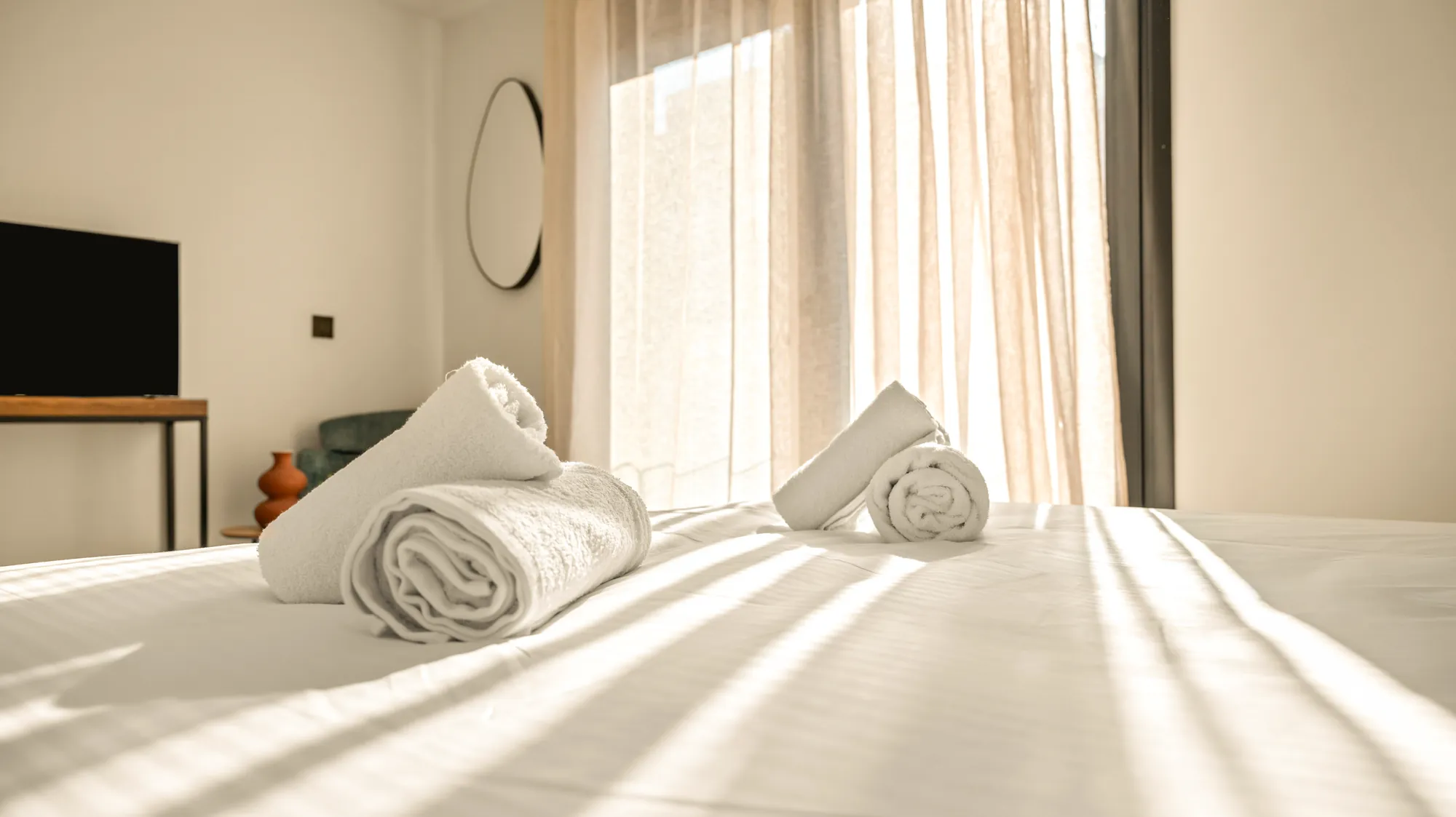 ORMOS Piraeus, the bed in sunlight, the television and mirror beyond