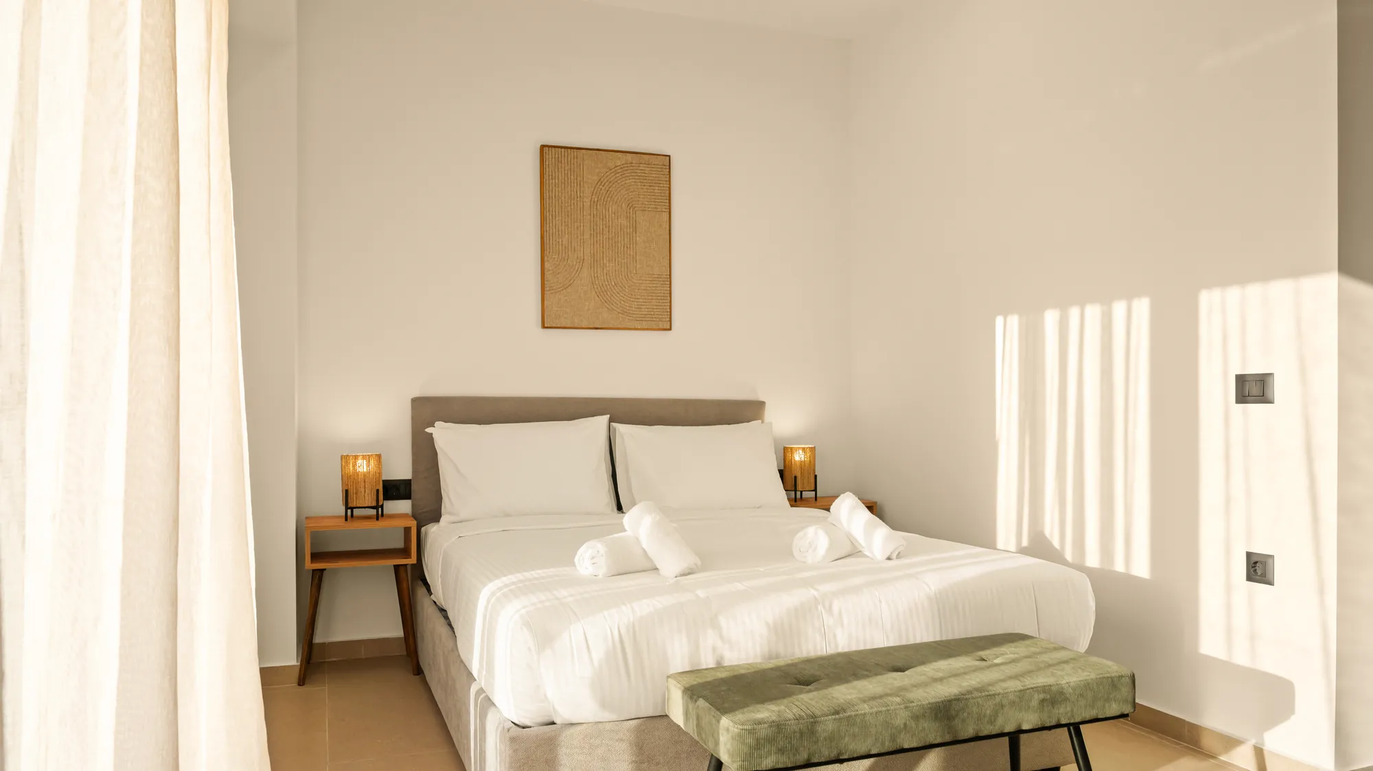 ORMOS Piraeus, the bed with its green bench, the artwork above the headboard