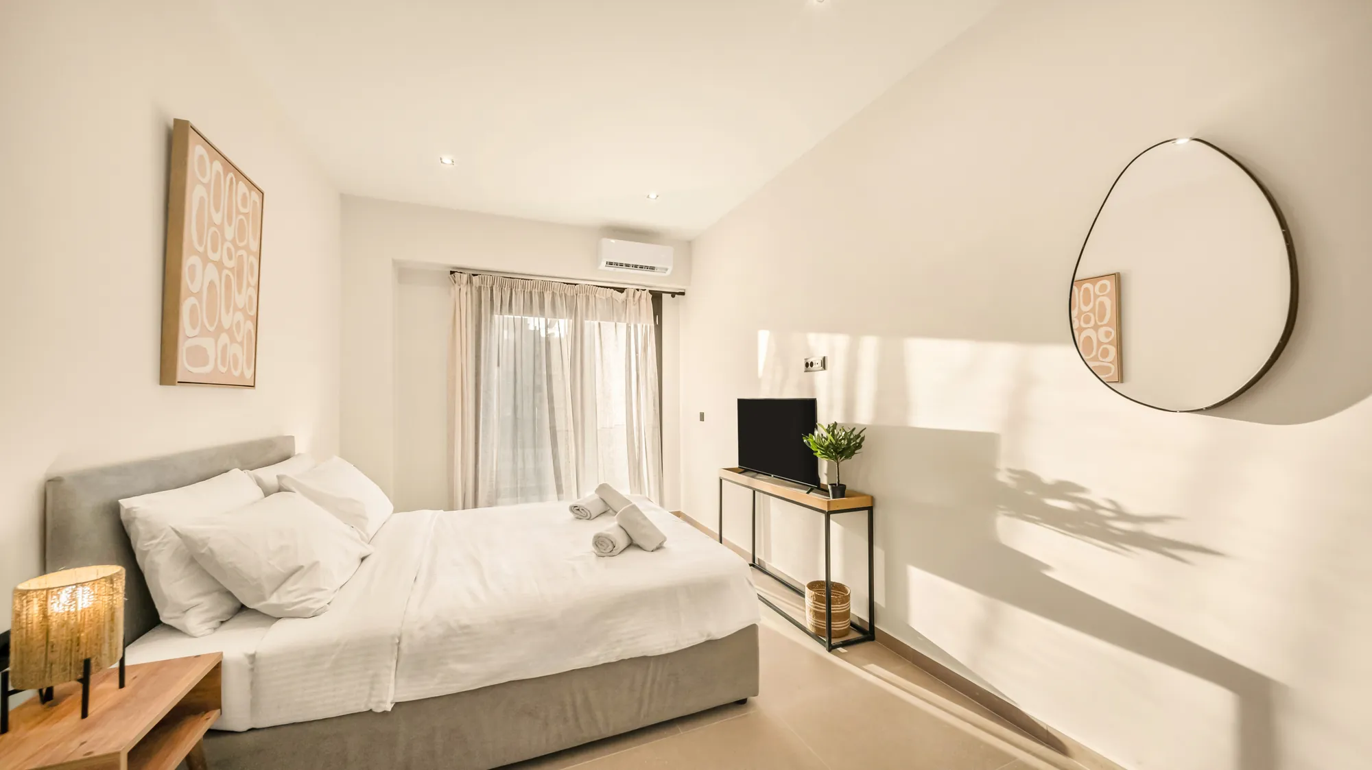 ORMOS Piraeus, the bed, the console and the mirror on the sunlit wall
