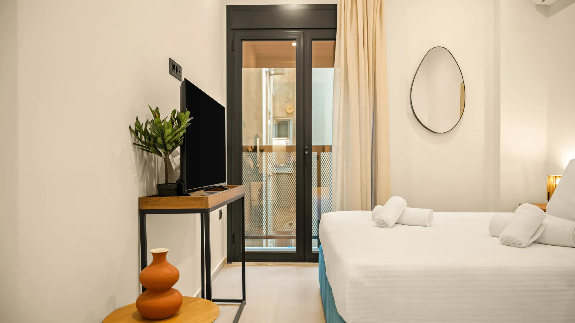 ORMOS Piraeus, the balcony door, the television and the bed