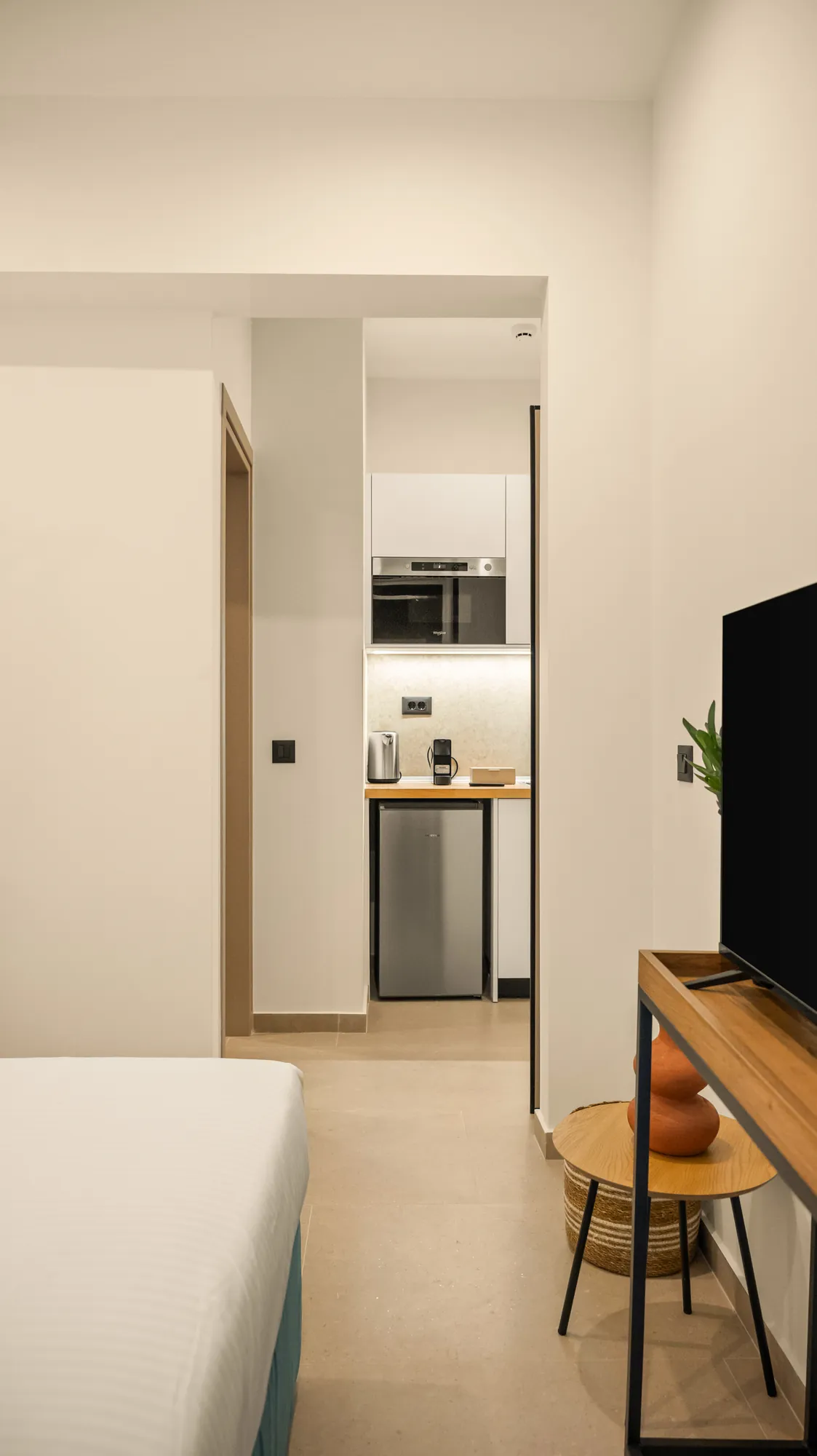 ORMOS Piraeus, the kitchenette seen past the console and the bed