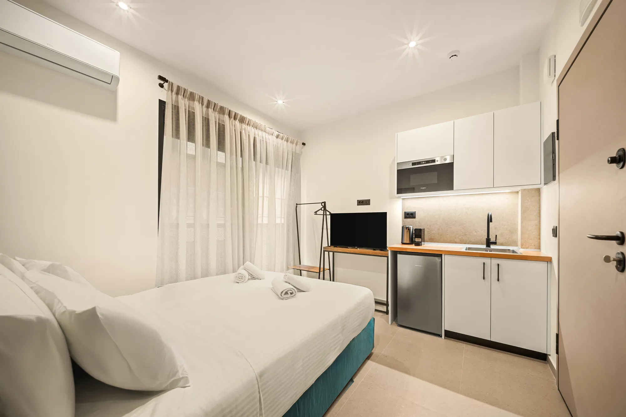 ORMOS Piraeus, the bed and the kitchenette beyond