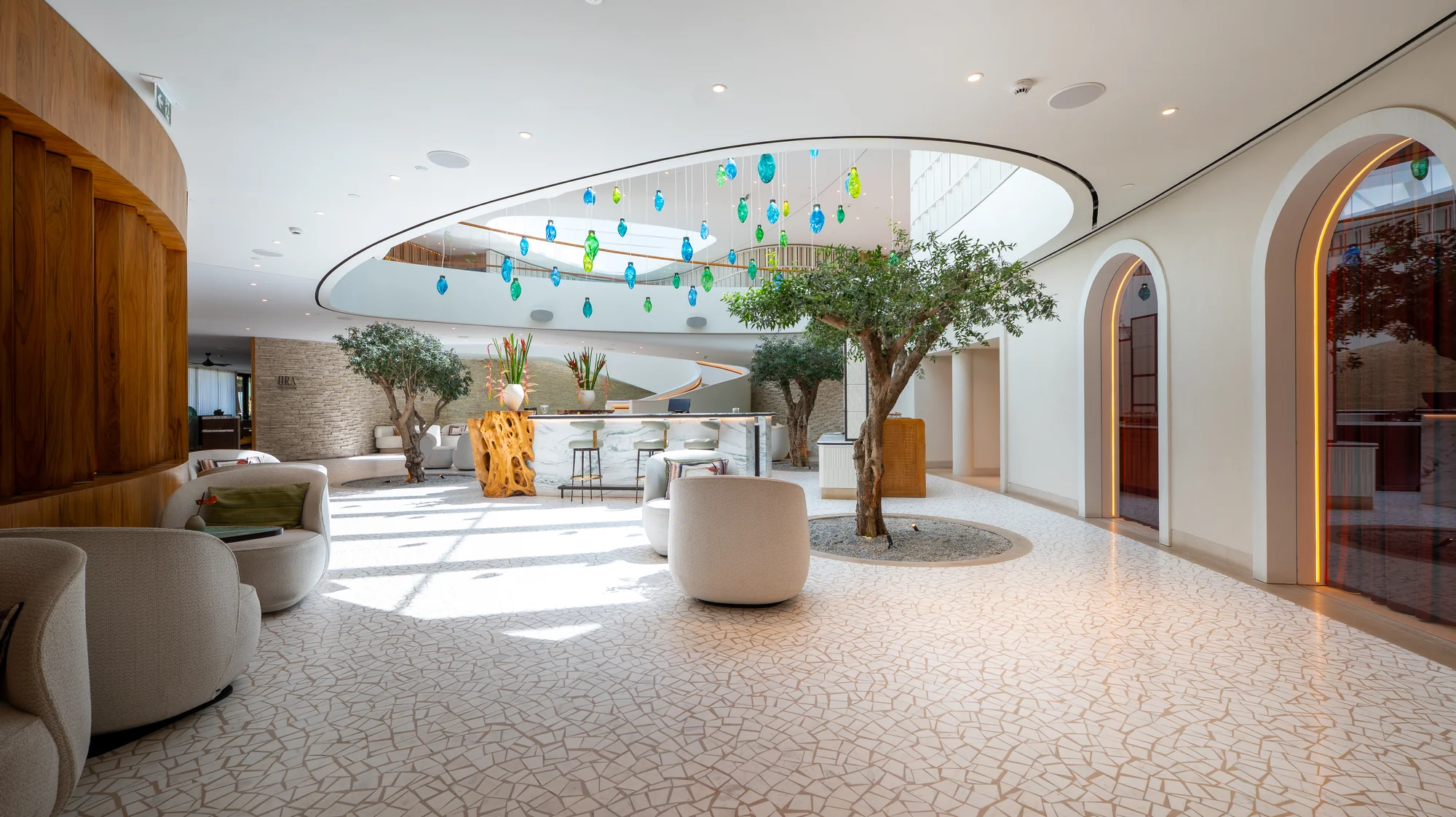 One&Only Aesthesis, the lobby lounge with arched openings and an olive tree