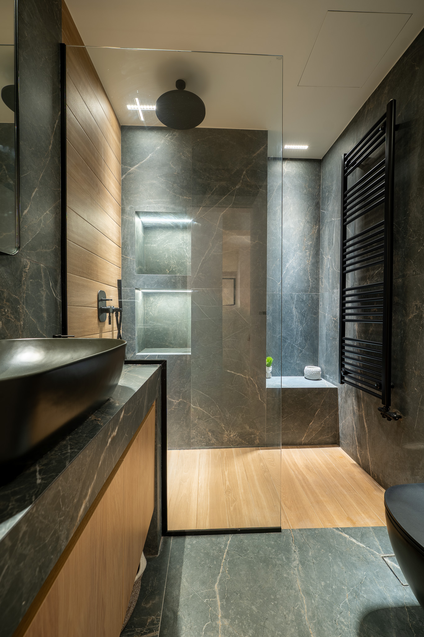 A&K Chorothetisis, guest bath with grey marble walls, oak shower floor and matte-black hardware