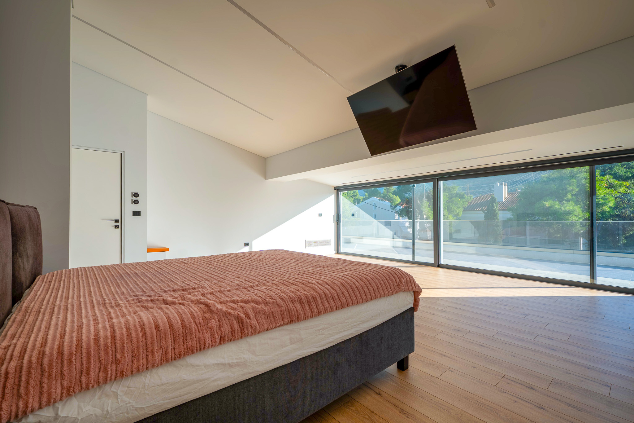 Villa Bond, master bedroom with drop-down TV and full-width glass