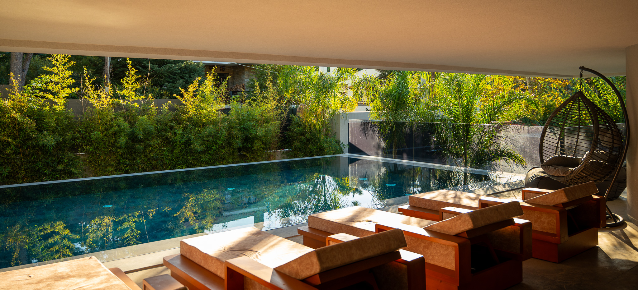 Villa Bond, golden-hour covered terrace with infinity pool