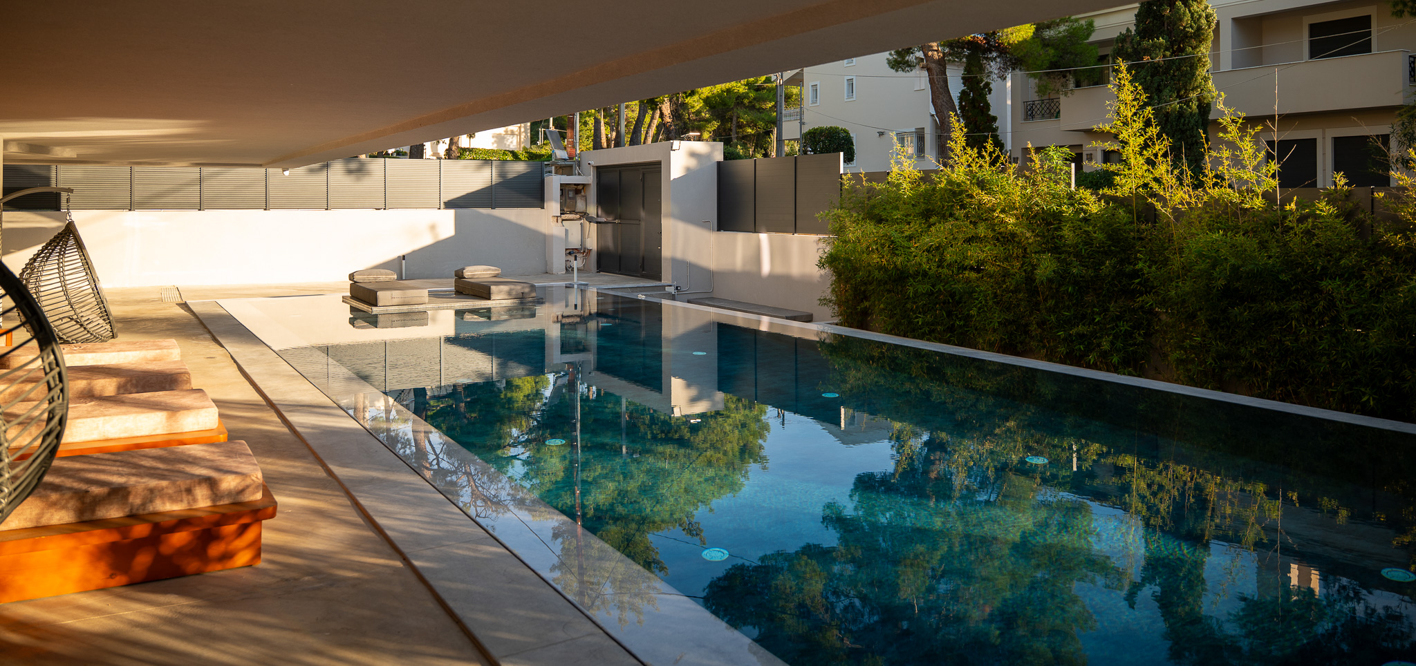 Villa Bond, pool with palms and shower wall in golden cast