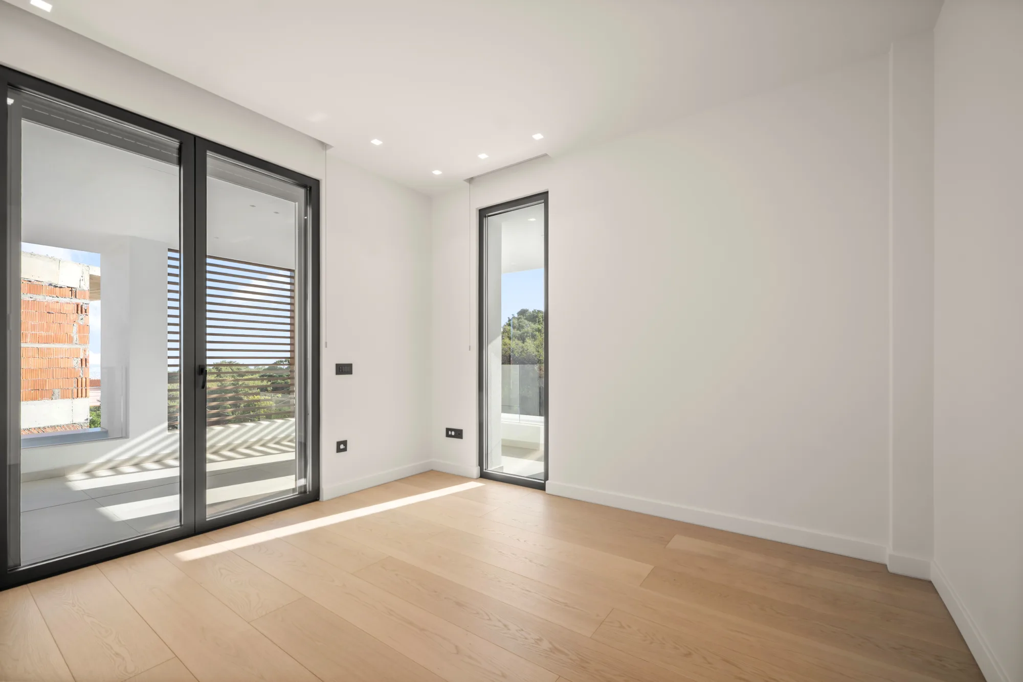 Villa Eden, bedroom with wood floor and full-height glazing