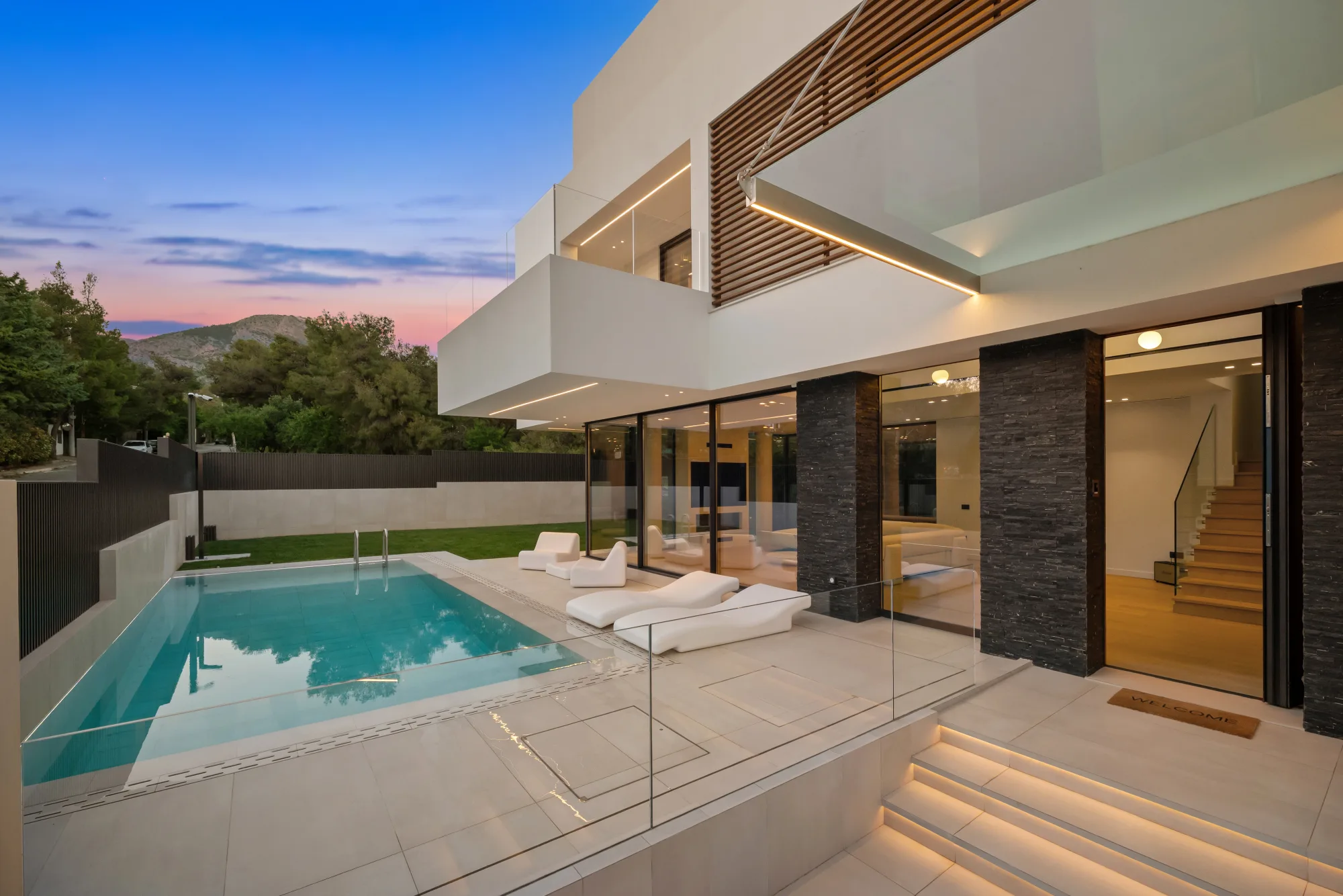 Villa Eden, villa and pool at dusk with warm interior light