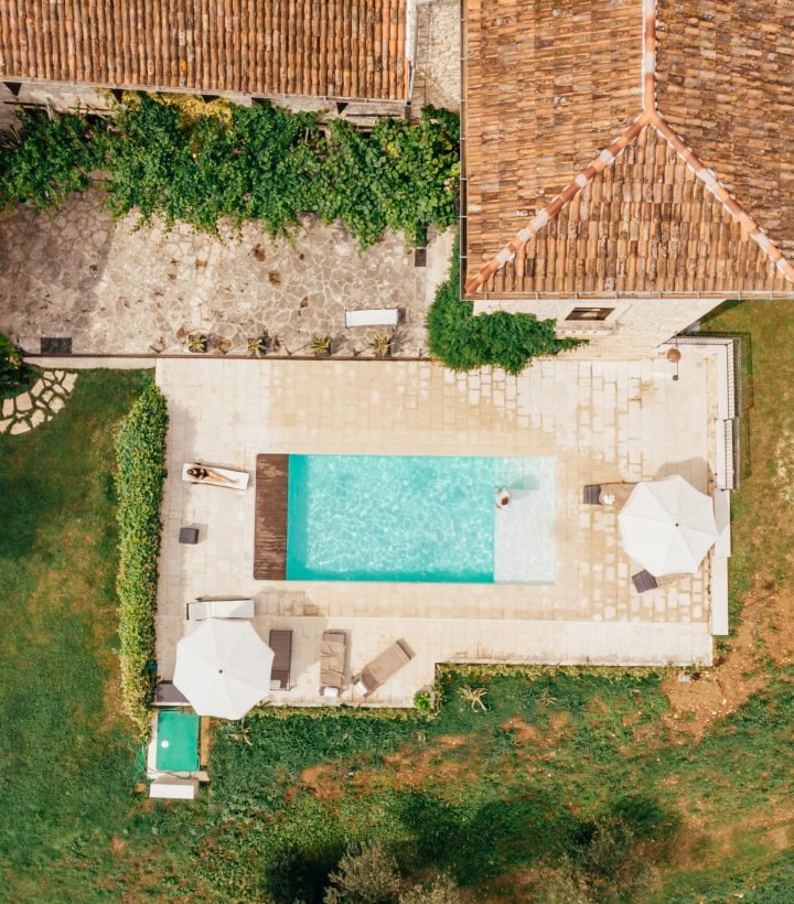 top view of man and woman resting at swimming pool near villa in Italy